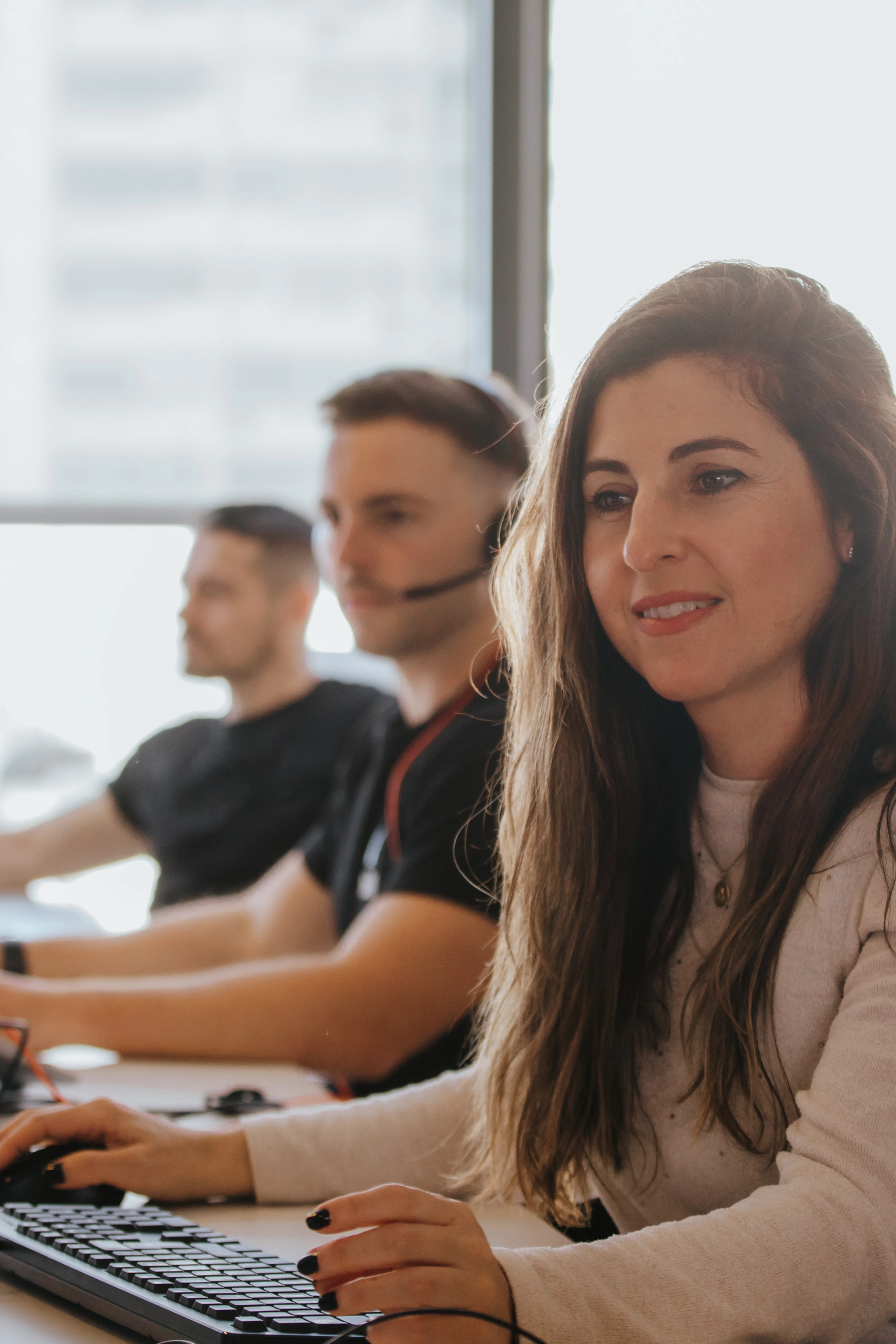 Photo of three employees working at their desks