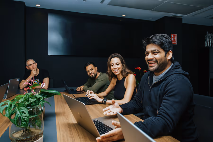 Employees sitting in the office, smiling in a meeting